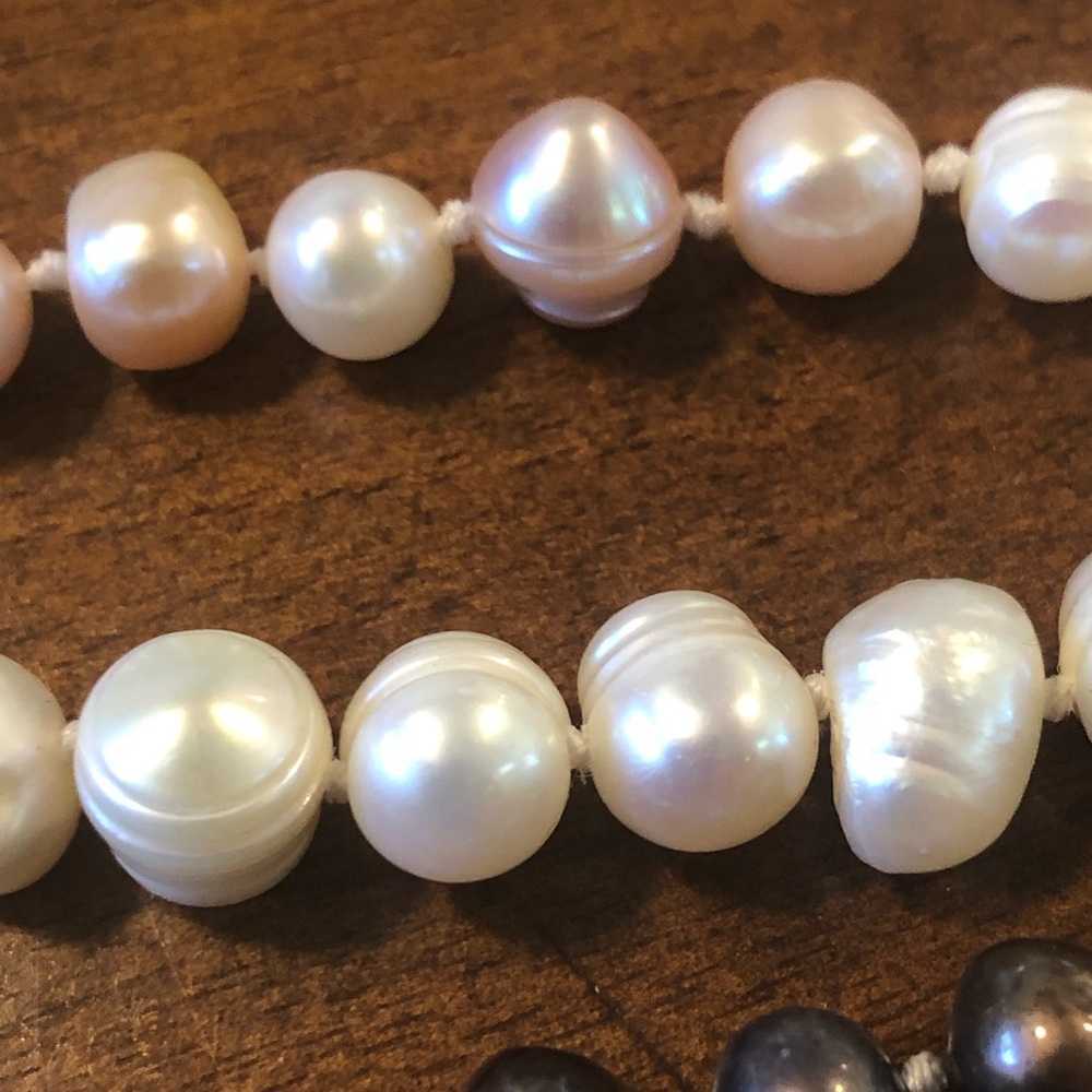 Three strands of natural pearls. Black pink white